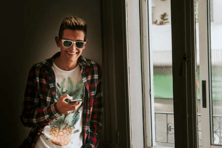 flapper with mobile phone in the home windowの写真素材