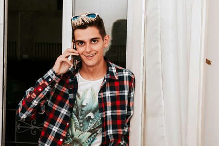 fashionable young man talking on the mobile phoneの写真素材