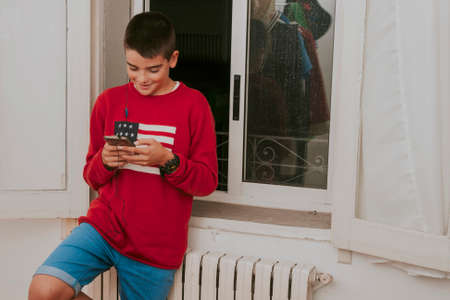 young boy listening to music with mobile phoneの写真素材