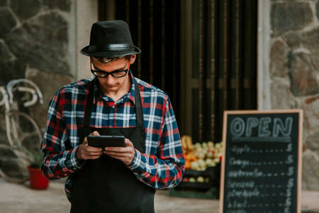 young man with the tablet in the entrance of your business