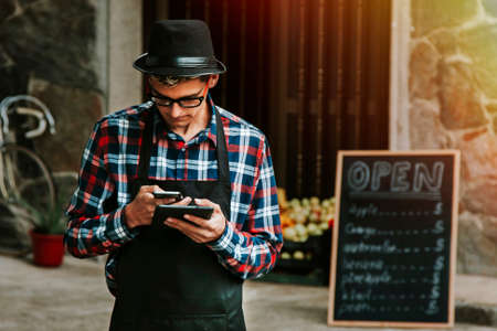 young man with the tablet in the entrance of your businessの写真素材