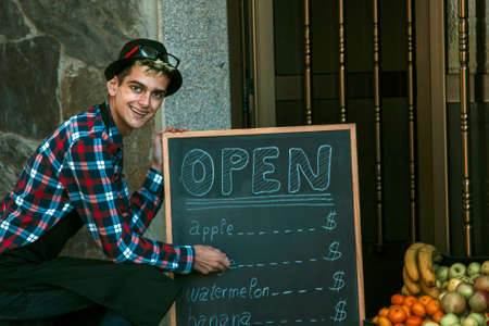 young man in his tent with blackboard advertisingの写真素材