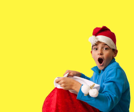 child on color background with christmas hatの写真素材