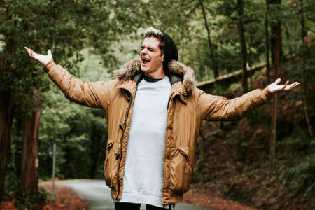 boy shouting in the forest with open armsの写真素材