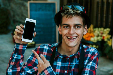 young businessman showing mobile phoneの写真素材