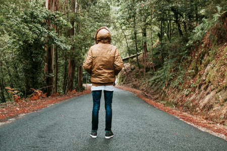 man with winter clothes on the road back