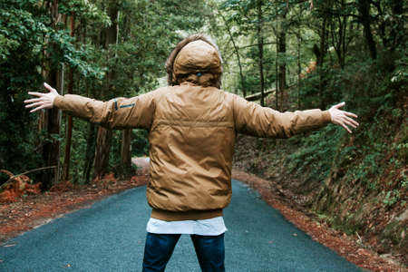 young man with open arms in forestの写真素材