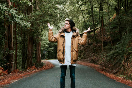 man with open arms in forest