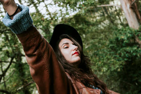 young woman enjoying autumn in the woodsの写真素材