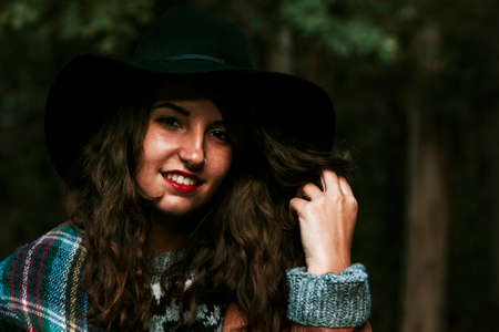 portrait of young woman with hat in the woodsの写真素材
