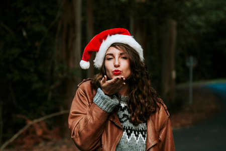 young woman with santa claus hat kissingの写真素材