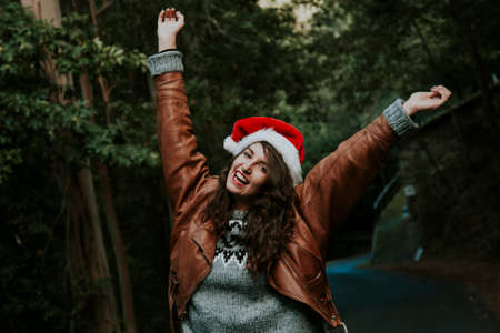 attractive young woman smiling with christmas hat outdoorsの写真素材
