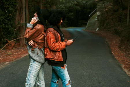 friends with the mobile phone and tablet outdoorsの写真素材