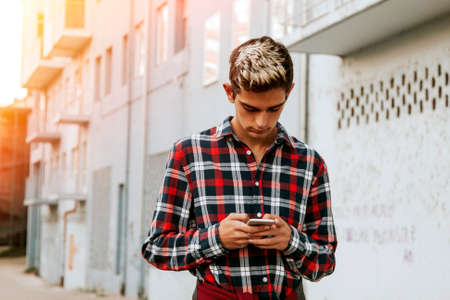 boy with the mobile phone on the city streetの写真素材