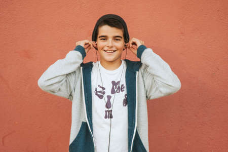 urban boy with headphones on the wall
