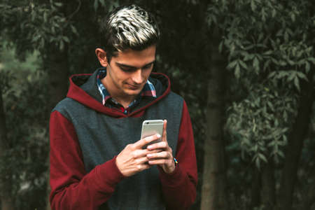 boy with the mobile phone on the streetの写真素材