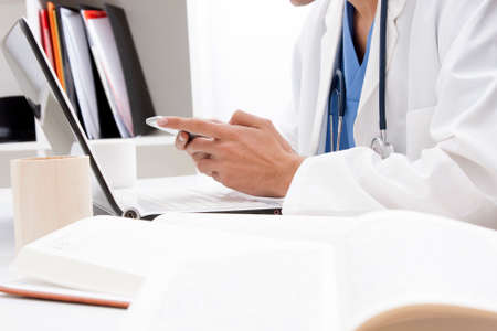 doctor with mobile phone in hands in office