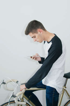 teenager with the mobile phone on bicycle vintage white background