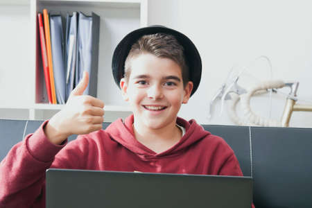 child with laptop at home and the sign of successの写真素材