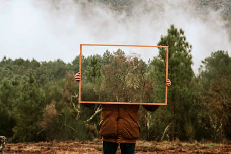 young holding frame with nature, concept of environmentの写真素材