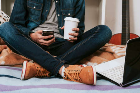 young man's casual style in the room in house with the mobile phone