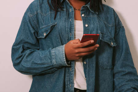 closeup of the hands of the girl young with jeans with the phone mobileの写真素材