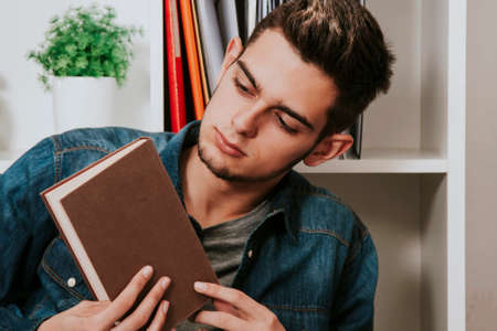 young man of modern and casual reading a book in the room in houseの写真素材
