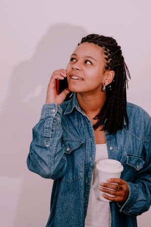 woman smiling speaking by phone with cup of coffee