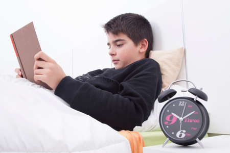 child reading in the room with the clock in the foregroundの写真素材