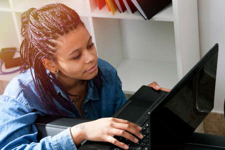 young woman of style casual with the computer laptop in the living room of Houseの写真素材
