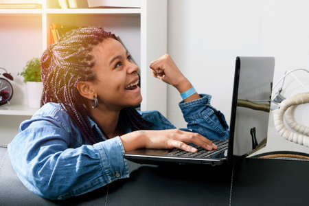 young woman happy with the computer laptop at home celebrating the success