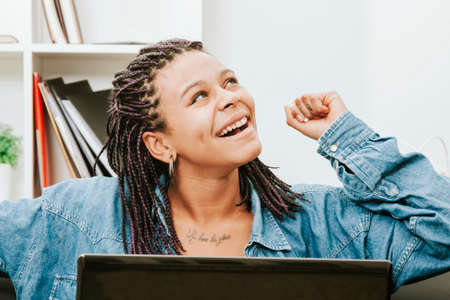 female young african descent with the computer in house celebrating with enthusiasm