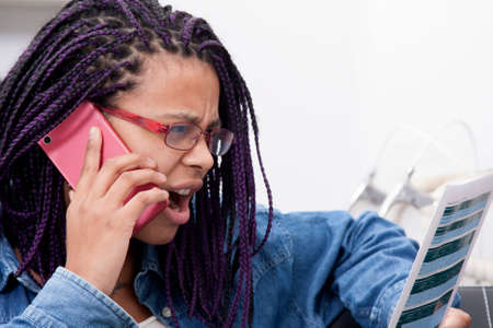 young woman at home buying by mobile phoneの写真素材