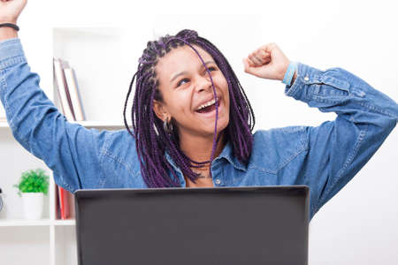 female young celebrating the success with the computer laptopの写真素材