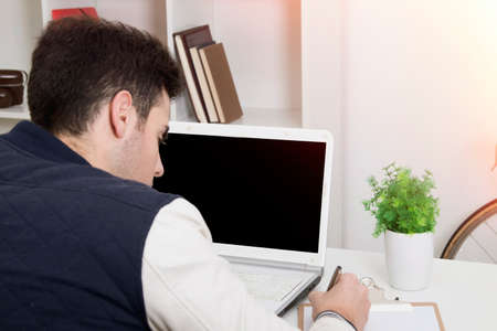 young in-house writing and studying with the laptop