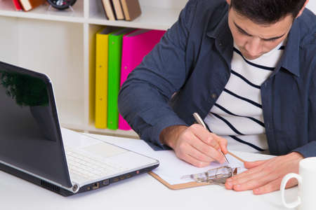 young woman studying at the desk with the laptop