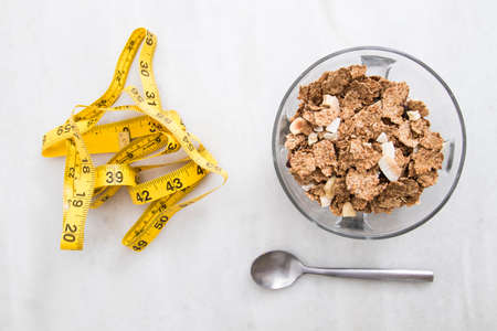 bowl of cereal with measuring tape, concept of slimming and healthy dietの写真素材