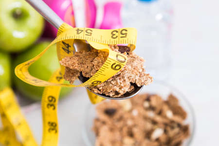spoon of cereal with measuring tapeの写真素材