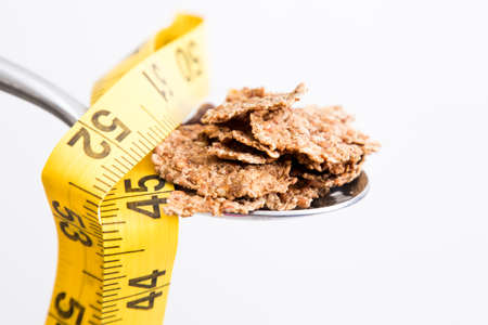 spoon of cereal with measuring tapeの写真素材