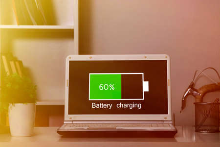 computer laptop charging the battery pack in the room at nightの写真素材
