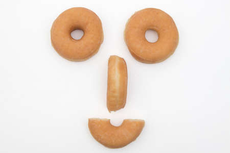 face smiling with donuts on background whiteの写真素材