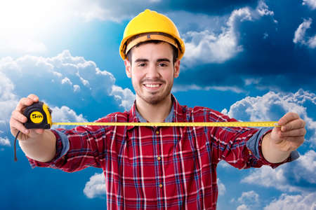 worker of the building smiling measuring with the metroの写真素材