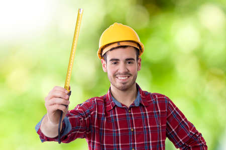 worker of the building smiling measuring with the metroの写真素材