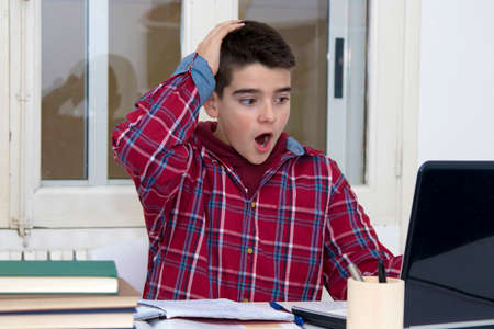 child with expression of surprise studying on the desktop