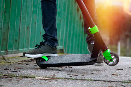 feet of the child in the scooter in the foregroundの写真素材