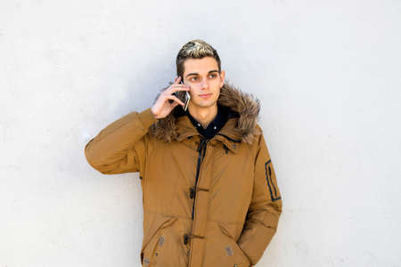young man with the phone on the wallの写真素材