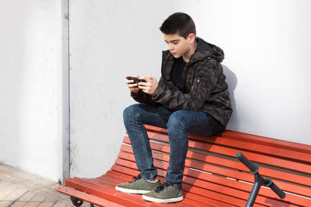 child in old school with the phone mobile to open airの写真素材