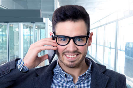 portrait of latin businessman with glasses talking by mobile phone