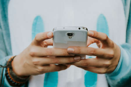 hands of a child disguised with mobile phoneの写真素材