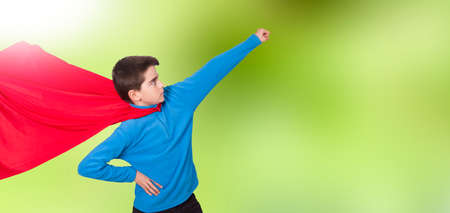 child with costume superhero in an attitude of strengthの写真素材